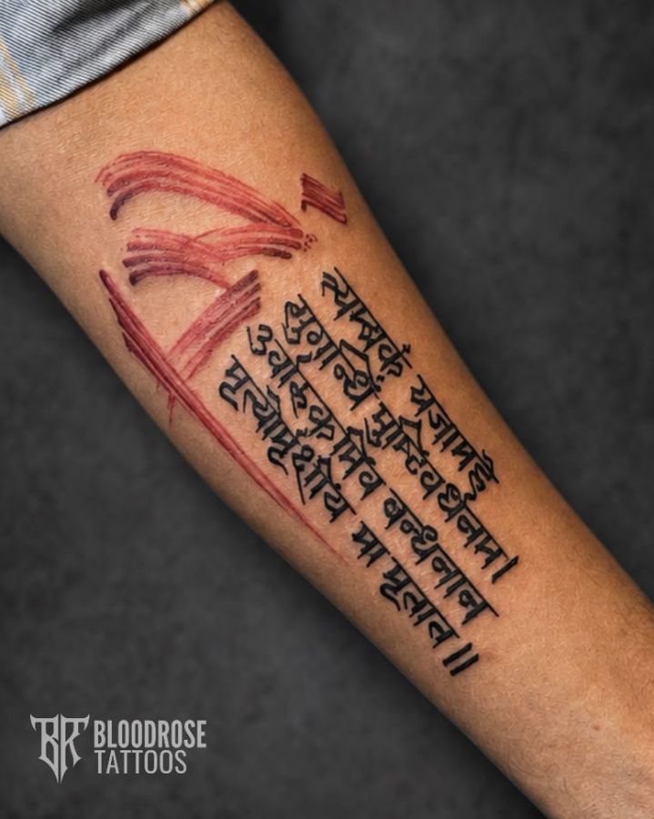 Sanskrit script tattoo with red brushwork